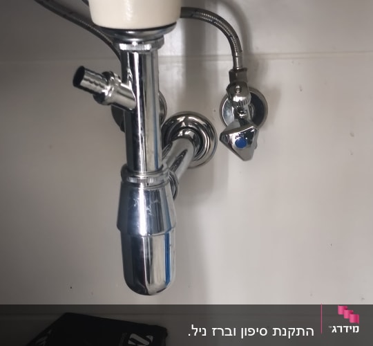 צנרת מתחת לכיור עם ברזים וכבלים
